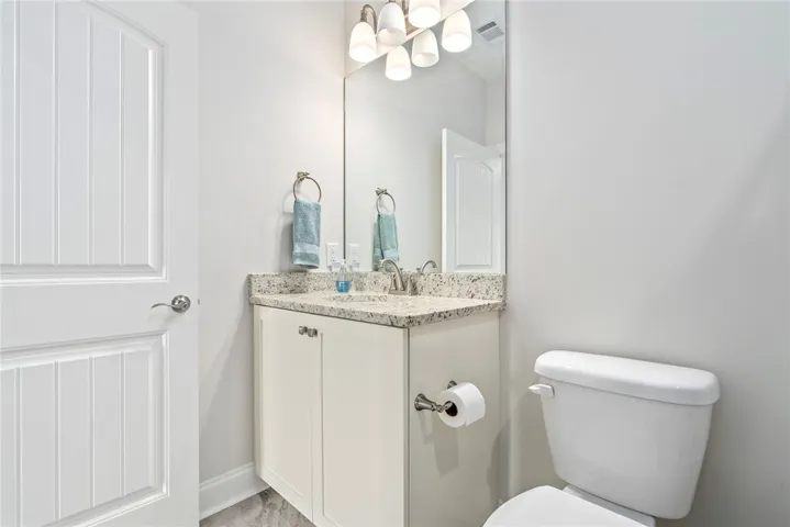 This sleek bathroom boasts granite counters and tile flooring for refined everyday living.
