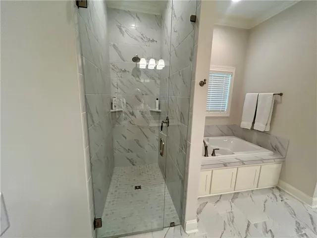 This primary bathroom features a spacious walk-in shower and a luxurious soaking tub for ultimate relaxation.