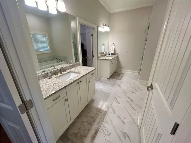 This spacious bathroom features double vanities and an inviting soaking tub for ultimate comfort.