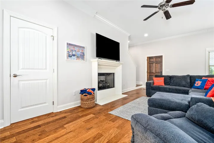 This inviting living area boasts rich hardwood flooring and a cozy fireplace, perfect for gatherings.