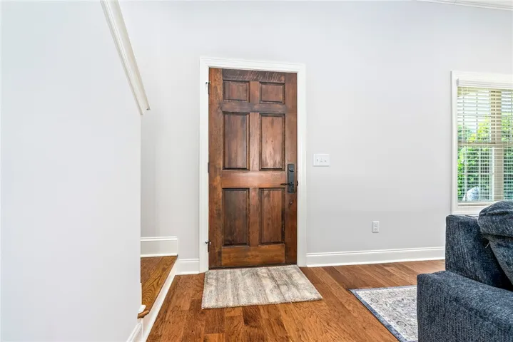 This inviting entry features a classic wooden door and gleaming hardwood floors.