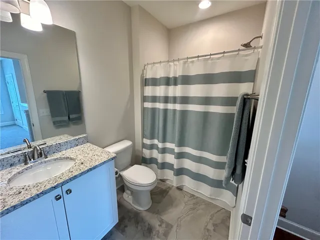 This bright bathroom features a modern vanity and a spacious shower area.
