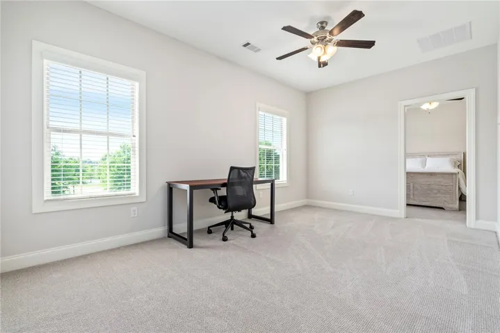 This bright room offers carpeted comfort and ample light, perfect for a dedicated home office or guest quarters.