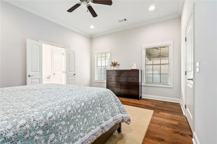 This spacious bedroom offers ample light and comfortable hardwood floors.