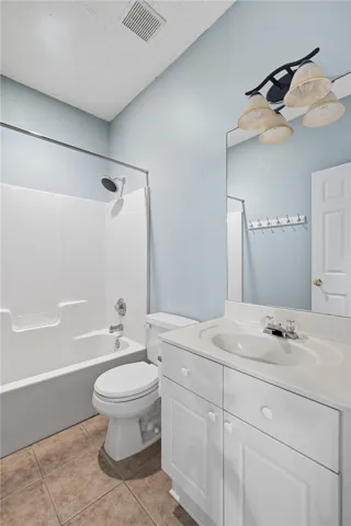 This bright bathroom features a spacious tub and a practical vanity.