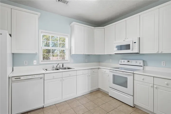 This spacious kitchen features ample cabinetry and a functional layout, perfect for daily living.