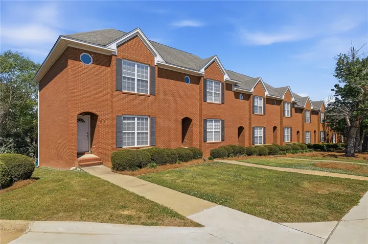 This brick townhome offers comfortable living with a well-maintained exterior and mature landscaping.