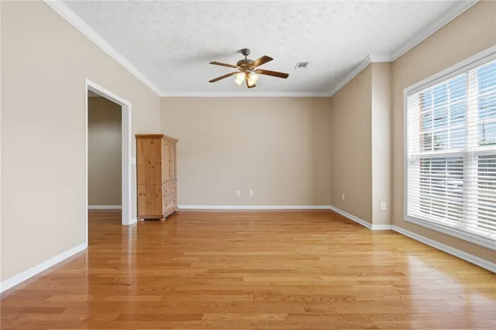 This versatile living area features warm wood flooring and abundant natural light.