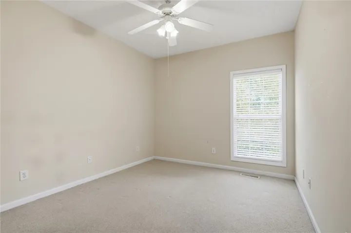 This spacious room features vaulted ceilings, a large window, and soft carpeting.