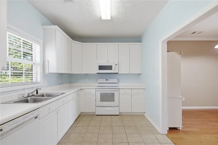 Bright and airy, this kitchen features ample cabinetry and a serene atmosphere perfect for culinary endeavors.
