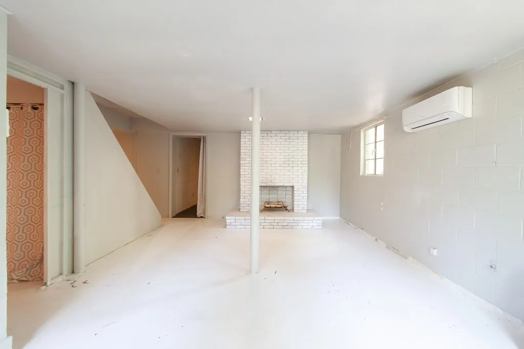 This expansive basement area offers versatile living options with a cozy fireplace and abundant natural light.