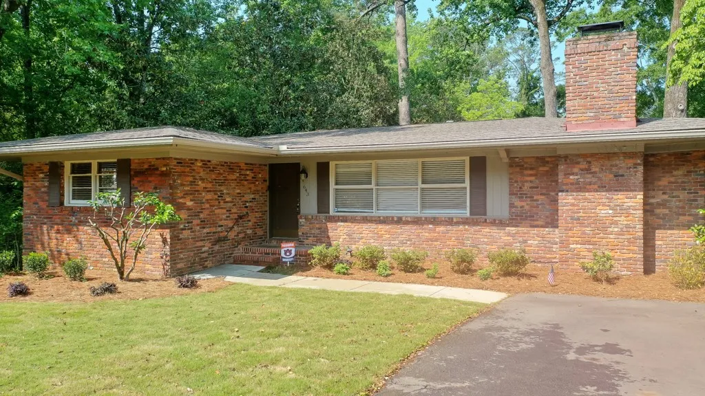 This classic brick residence features a lush lawn and a welcoming entryway.