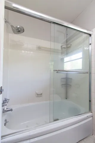 This bathroom features a pristine white bathtub and shower combination.