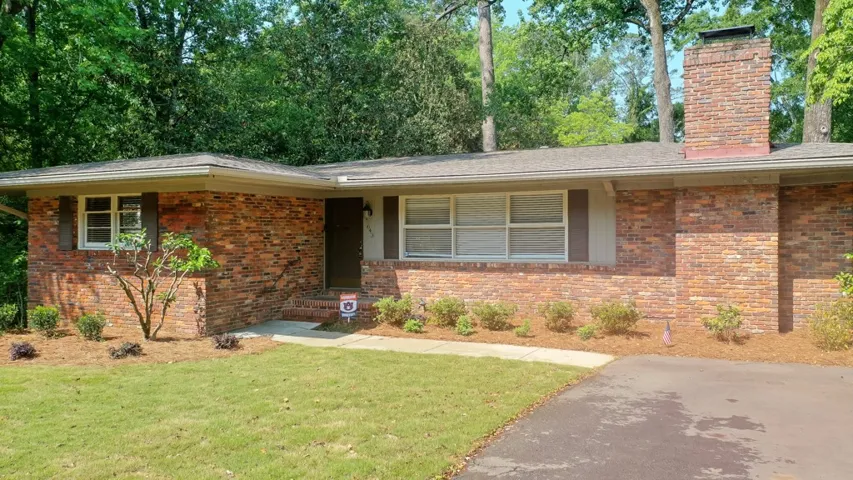 This classic brick residence features a lush lawn and a welcoming entryway.