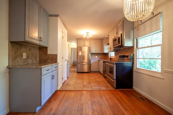 This spacious kitchen offers ample cabinetry, modern appliances, and beautiful flooring.