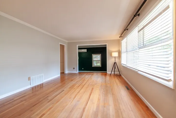 This bright living space features polished hardwood floors, crown molding, and abundant natural light.