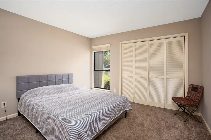 This cozy bedroom features a large window and ample closet space.