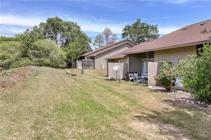 This private backyard features lush greenery and a charming patio area.