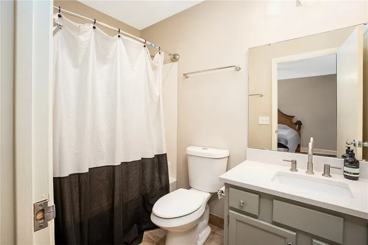 This bathroom features a sleek vanity and convenient shower area, offering practical comfort.