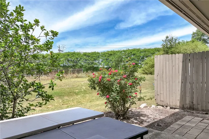 Enjoy outdoor living in this private yard with ample green space and a charming rose bush.