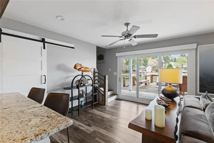 This inviting space features an open concept, sliding doors leading to a dock, and modern barn door accents.