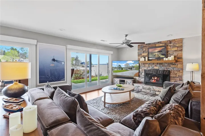 This inviting living area boasts a cozy fireplace and expansive views of the outdoors.