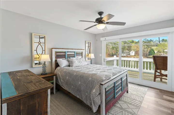 This cozy bedroom features direct access to outdoor living with picturesque waterfront views.