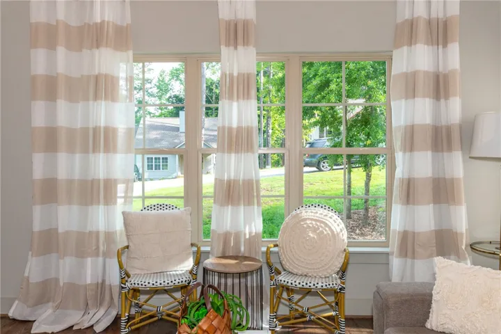 Bright windows frame lush outdoor views, creating a serene and inviting atmosphere in this welcoming space.