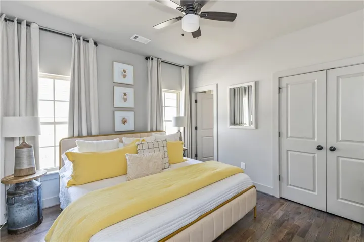 This inviting bedroom features rich hardwood flooring and a ceiling fan for optimal comfort.