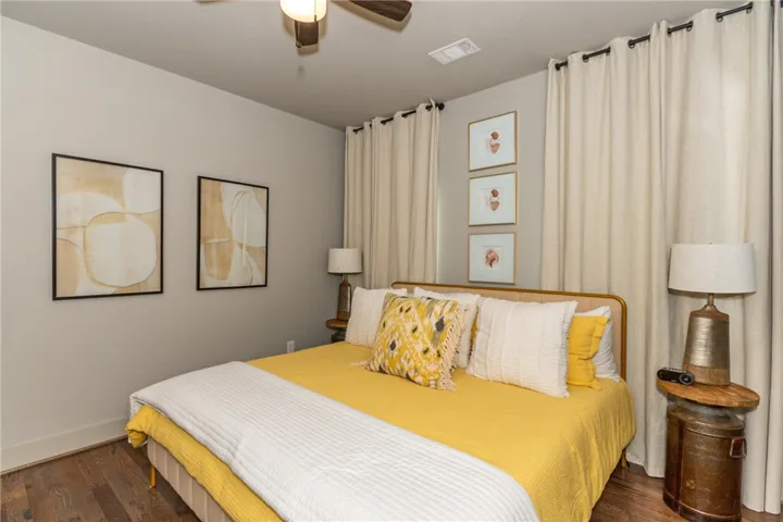 This inviting room features warm wood flooring and a refreshing ceiling fan for ultimate comfort.