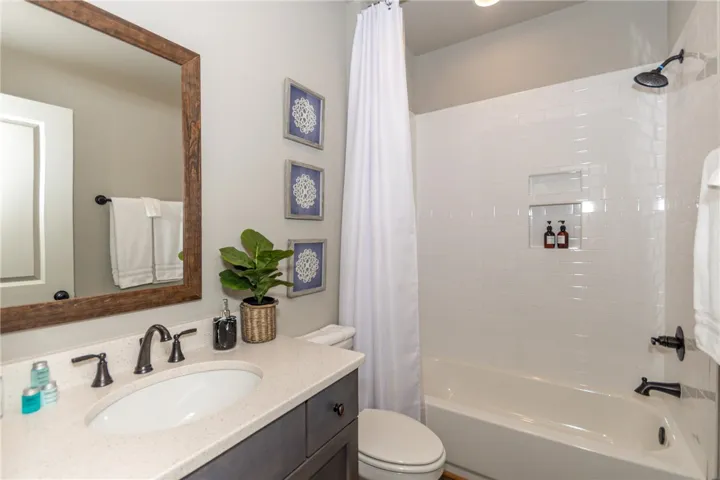 This clean and inviting bathroom features a modern vanity and a classic tub-shower combination.