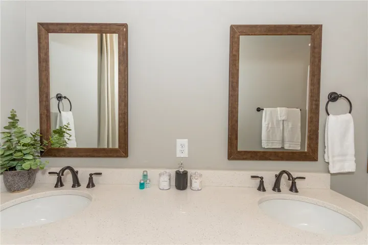 This bathroom features a double vanity with two sinks, granite counters, and individual mirrors.