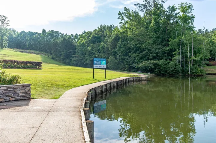 Scenic lakeside path leading to lush greenery, offering tranquil waterfront access.