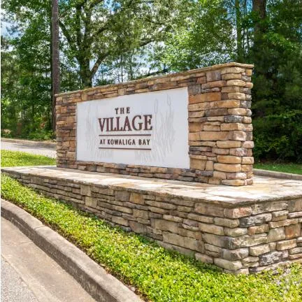Welcome to this charming community, featuring a stately stone entrance with lush landscaping.