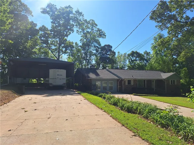 This residence features a well-maintained exterior, a driveway, and mature trees, offering a private setting.