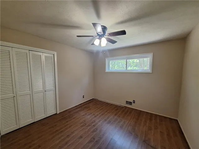 This inviting room features warm wood flooring and ample natural light, creating a comfortable living space.