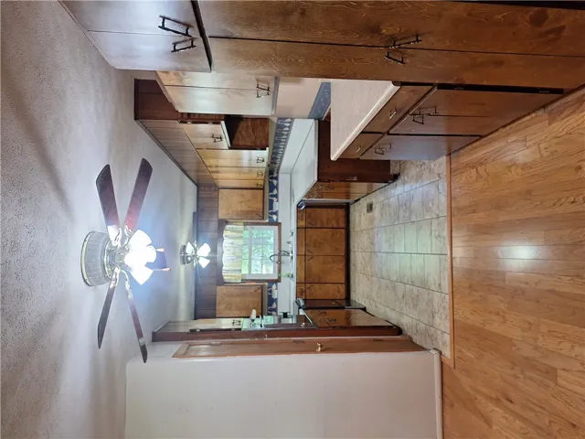 This spacious kitchen offers ample cabinetry and combines hardwood and tile flooring for a classic appeal.