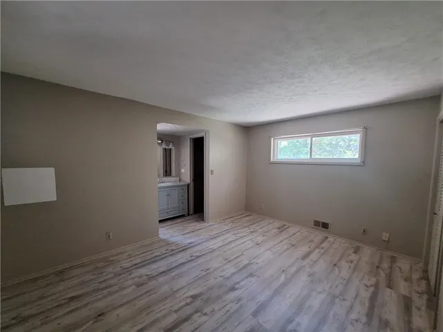 This primary bedroom offers durable flooring and an adjoining bathroom.