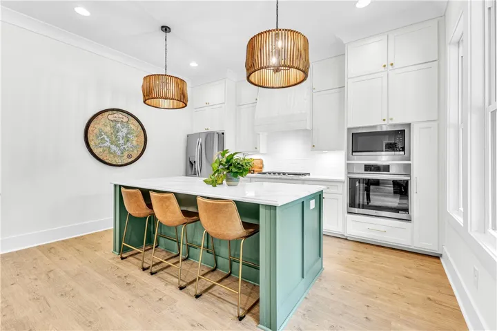 An inviting kitchen features a central island, recessed lighting, and stainless steel appliances.