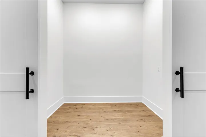 An inviting open entry reveals a spacious closet area with durable hardwood-style flooring.