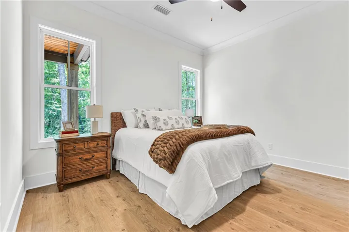 A tranquil primary bedroom with rich wood flooring and abundant natural light.