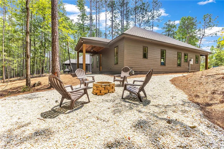 A tranquil woodland setting features a charming fire pit area, perfect for relaxed outdoor gatherings.