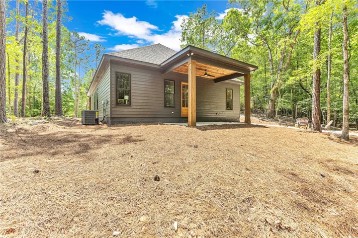 A private, secluded outdoor retreat with a spacious covered patio set amidst a peaceful woodland backdrop.
