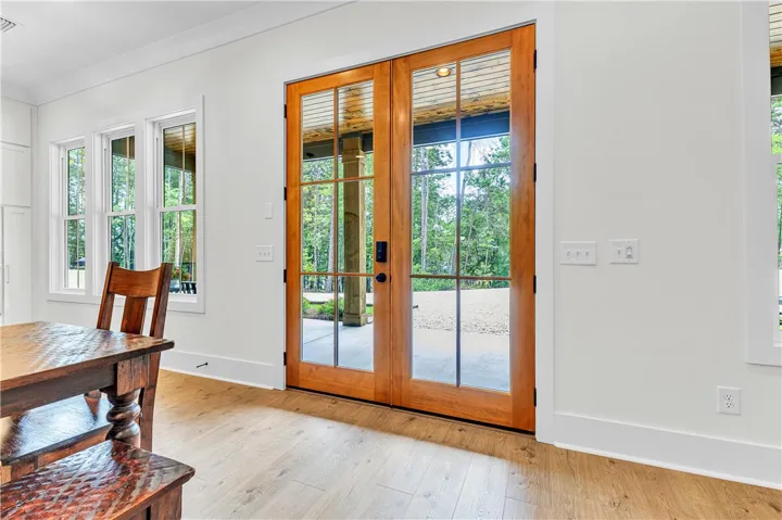 French doors and large windows invite natural light and scenic outdoor views into this inviting space.