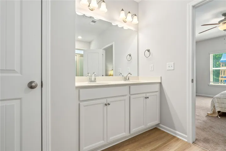 Double vanity with ample counter space and cabinet storage creates a practical bathroom.