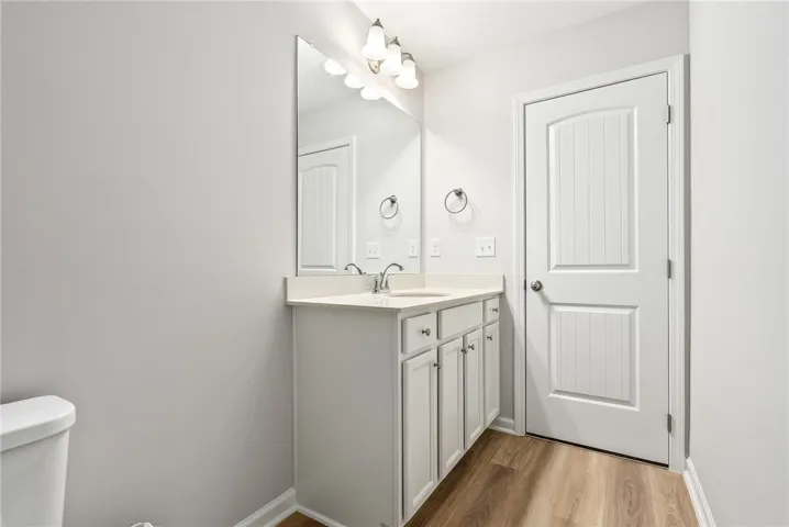 A pristine bathroom featuring a single vanity with ample storage and sleek, modern finishes.