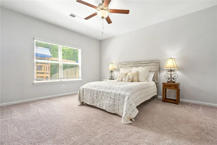A quiet retreat, this bedroom offers ample natural light and plush carpeting.
