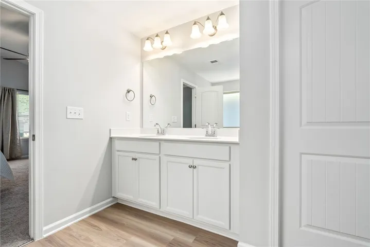 Double vanity with ample counter space creates a functional and inviting primary bathroom.