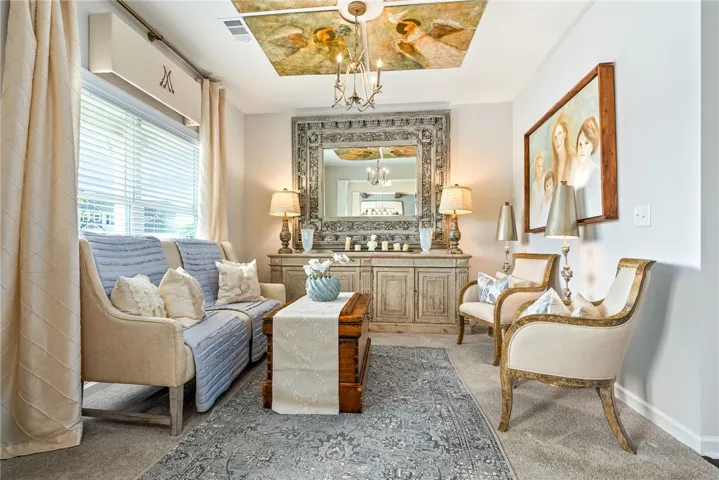 This bright living space features a captivating ceiling detail, creating an inviting ambiance.