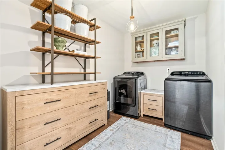 This laundry area features contemporary appliances and ample storage, making chores a breeze.